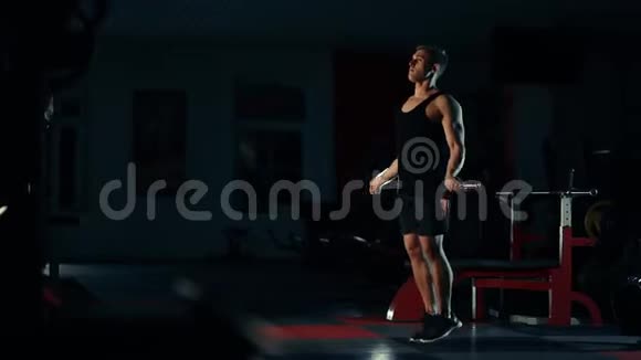肌肉男在健身房锻炼用绳子训练腿部跳跃有选择棒健身和健美的概念视频的预览图