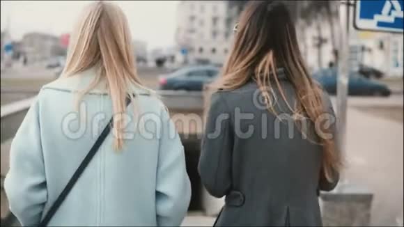 两位女士走到一个行人隧道穿着时髦衣服的朋友来到地铁朋友们一起散步视频的预览图