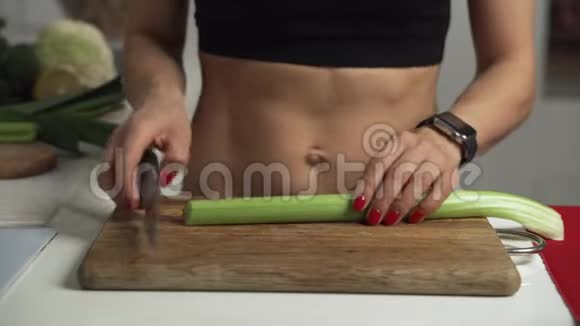 运动的女人在切菜板上切芹菜做自制蔬菜沙拉视频的预览图