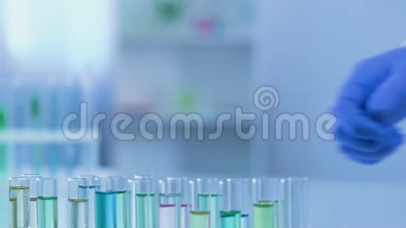 实验室助理观看玫瑰色液体试管化妆品开发视频的预览图