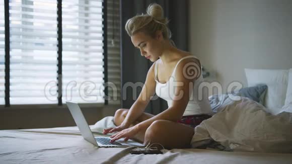 女人在床上用笔记本电脑思考视频的预览图