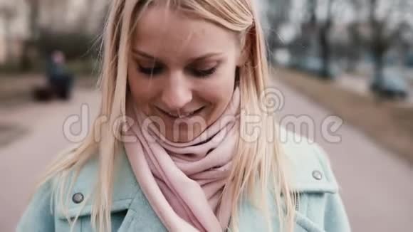 慢动作快乐的白种人女人发短信微笑穿着时髦的20多岁金发女郎走路时发短信快关门视频的预览图