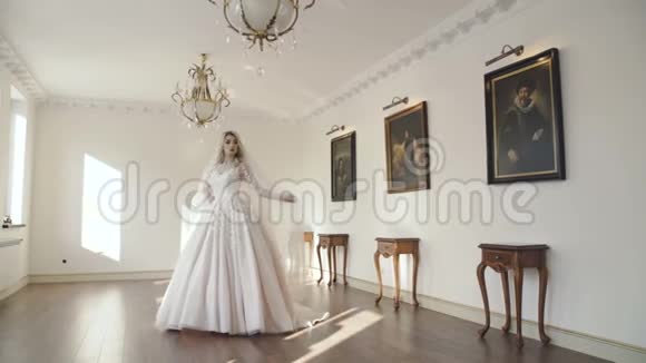 华丽的新娘站在房间的中央戴着面纱视频的预览图