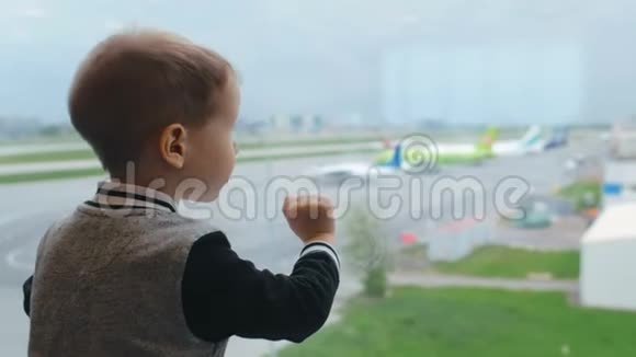 小男孩看着机场的飞机视频的预览图