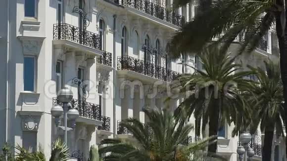 海岸线上有棕榈树的酒店建筑视频的预览图