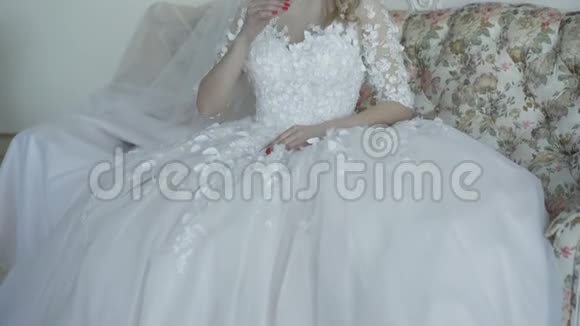 美丽新娘的肖像坐在沙发上微笑着看着相机4K视频的预览图