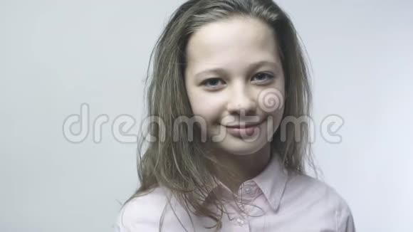 这位女孩的特写肖像看着镜头脸上带着轻微的微笑少女与美丽视频的预览图