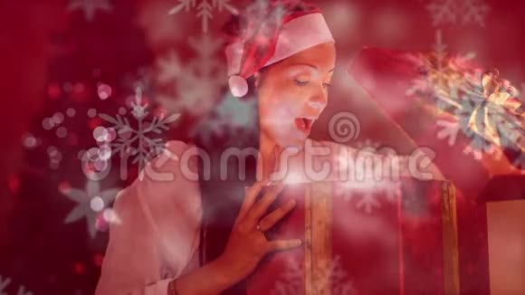 兴奋的女人打开带有雪花的神奇圣诞礼盒视频的预览图