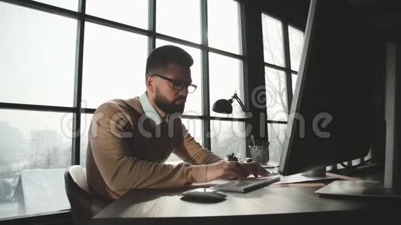 白人男子正在风格阁楼办公室工作笔记本电脑视频的预览图