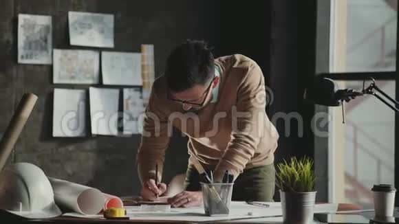 男建筑师用蓝图工作站在桌子前视频的预览图