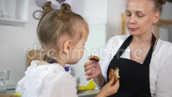 快乐的小女儿和妈妈一起吃自制的煎饼视频的预览图
