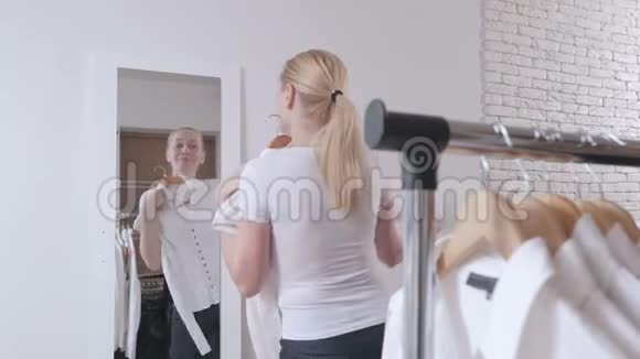 女人在商店里挑选衣服在镜子前仰慕视频的预览图