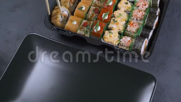 女人把寿司卷放在盘子里桌子上摆着一大套卷日本食品视频的预览图