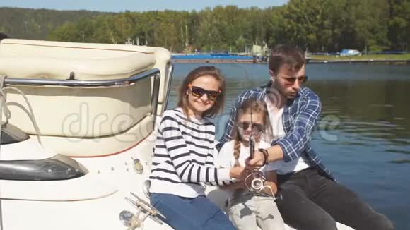 秋天和女儿在池塘钓鱼的幸福家庭视频的预览图