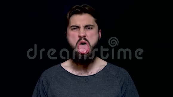 情感和胡须年轻英俊的黑发男子嘴伸出舌头试图戏弄年轻的胡子视频的预览图