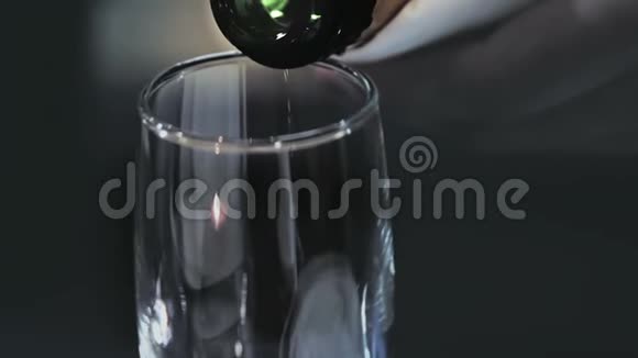 香槟酒从瓶子的颈部倒入玻璃表面有火花气泡上升视频的预览图