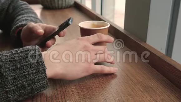 坐在咖啡馆里的男人用她的电话视频的预览图