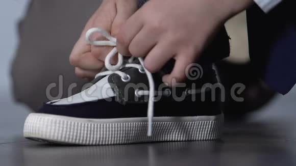 男孩系鞋带准备上学童年独立孩子时尚视频的预览图