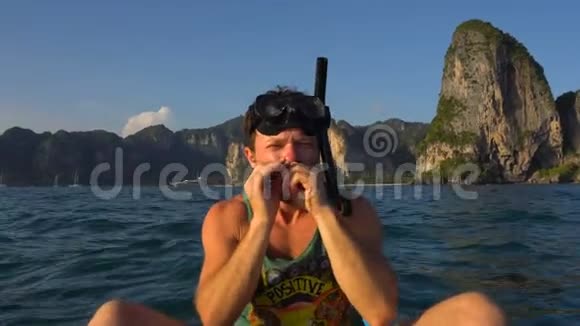 人在开阔的海水中用面具和管子在皮艇上弹奏竖琴用于潜水或浮潜泰国克拉比莱海滩视频的预览图