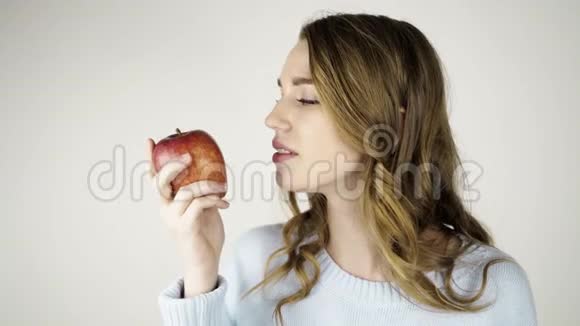 漂亮的头发女人咬着红苹果调情视频的预览图