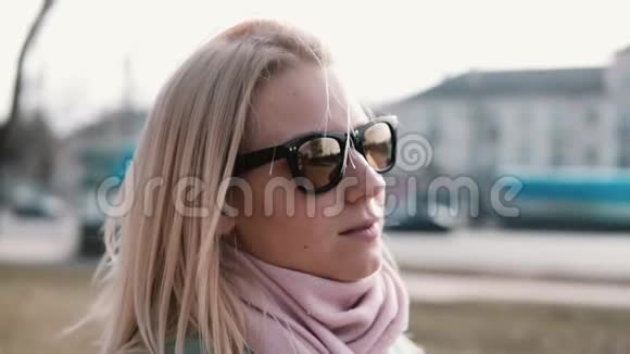 一幅迷人的白人女孩的肖像漂亮的30多岁的金发女性戴着时尚的太阳镜头发飞扬视频的预览图