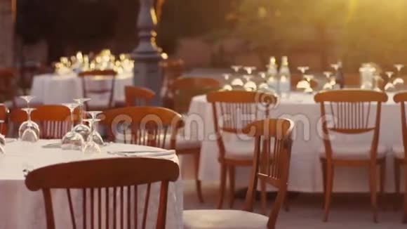 配备酒杯的桌子白色桌布和婚礼安排的木制椅子在阳光下意大利意大利视频的预览图