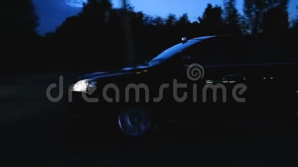 夜间在乡间小路上行驶的汽车浸过的灯光黄昏的旅程视频的预览图
