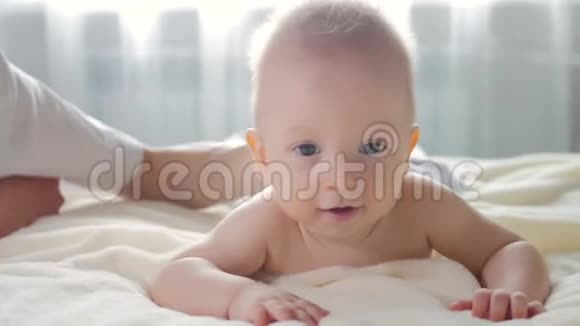 小男孩躺在她的腹部和放松在按摩妈妈给他七个月大的宝宝做背部按摩视频的预览图