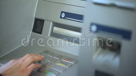 女性银行客户在ATM机上核对账户余额并收回她的卡视频的预览图