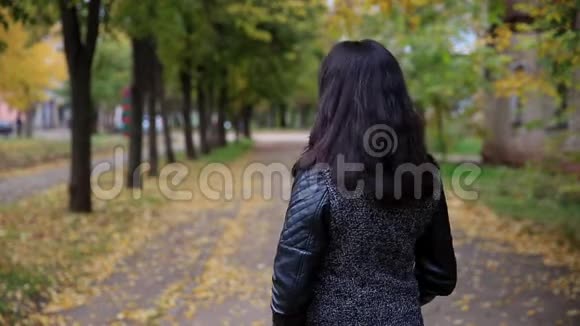在公园里漂亮的女人走路和转向摄像机视频的预览图