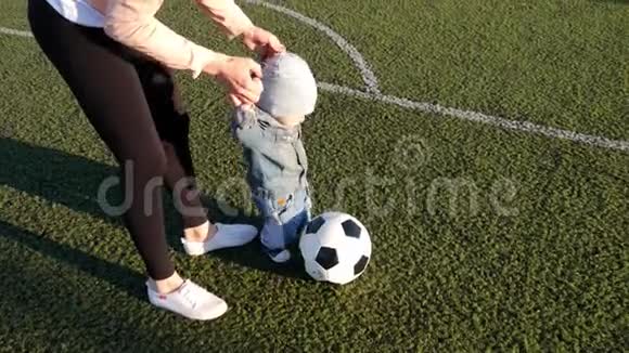 小男孩和他妈妈在足球场上踢足球视频的预览图