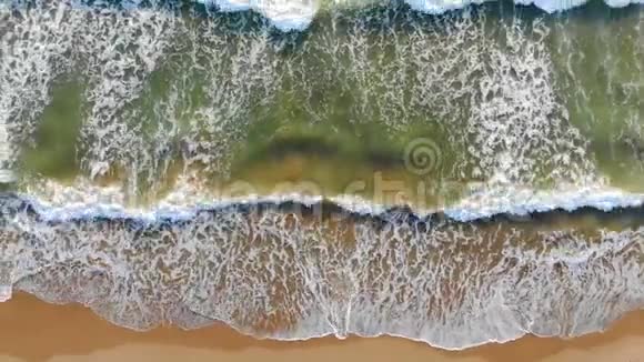 从空中俯瞰西班牙海滩海浪来到海岸在海岸外形成泡沫和气泡视频的预览图