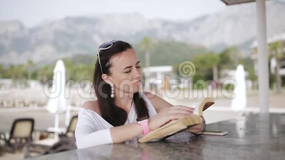 在大自然中阅读女人一边看书一边站在海边码头的酒吧视频的预览图