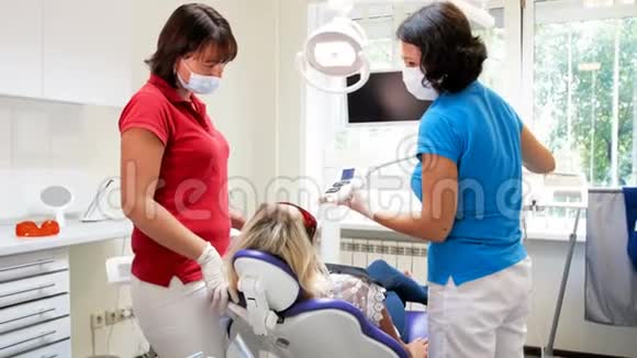 牙科医生为牙齿美白调整紫外线灯4k镜头视频的预览图