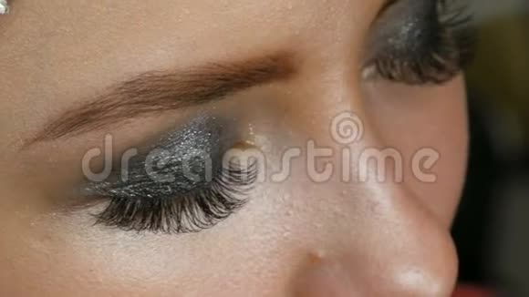 专业妆高时尚女孩模特用特殊的眉毛刷画眉毛时尚的烟熏眼视频的预览图