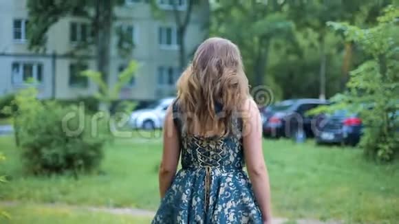年轻女子走过树旁的街道后景头发随风飘扬女孩转过身来慢点视频的预览图