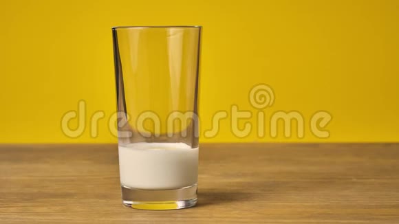自制的巧克力饼干堆在一张木桌上靠近一个带牛奶黄色背景的玻璃杯视频的预览图