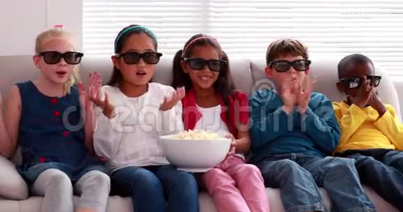 可爱的孩子在沙发上看3d电影视频的预览图