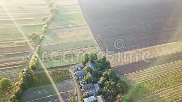 鸟瞰村庄在村庄和田野上空飞行视频的预览图