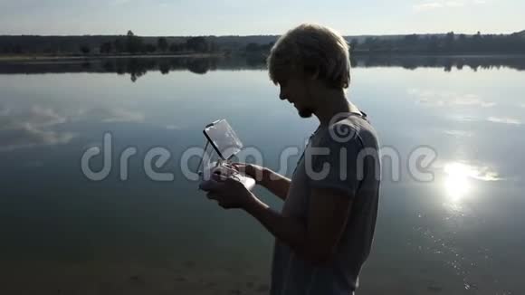 高科技人员看着他的面板在斯洛文尼亚的一个湖里操作一架无人机视频的预览图