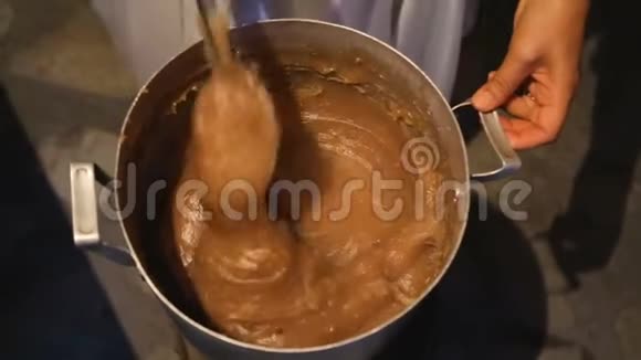 女性在大锅里搅拌美味的焦糖自制糕点店甜点视频的预览图