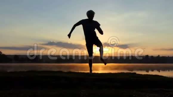 在日落时分的湖边有趣的男人跳起了狂欢的舞蹈视频的预览图