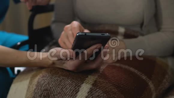 护士帮助老妇人使用手机方便老年人使用应用程序技术视频的预览图