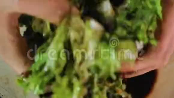 女性用手将生菜叶与醋混合沙拉成分接近视频的预览图
