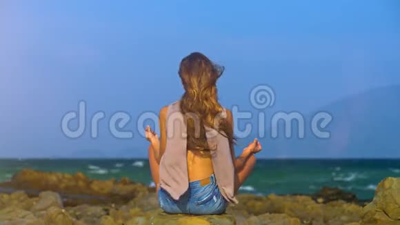 少女坐荷花束海风摇发背景视频的预览图