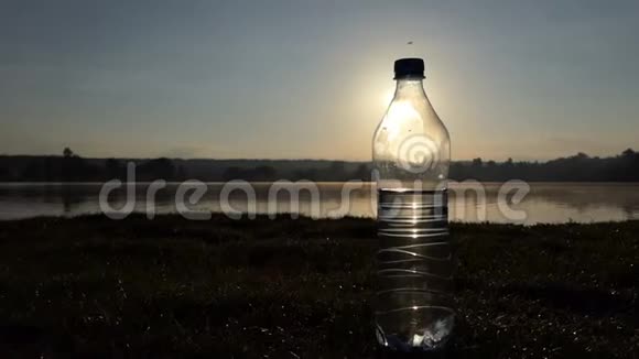 夕阳西下带水的塑料瓶在湖岸上摇晃视频的预览图