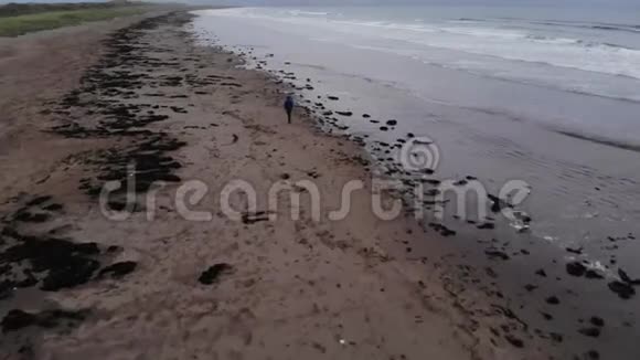 年轻人走过大西洋的海滩视频的预览图