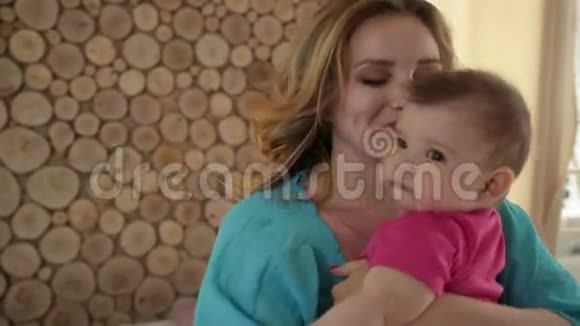 美丽的母亲摇着她的宝贝女儿睡觉视频的预览图