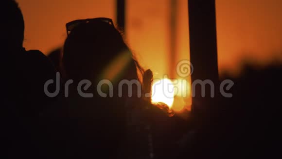 女人的剪影映衬着金色的夕阳夏日的景象视频的预览图