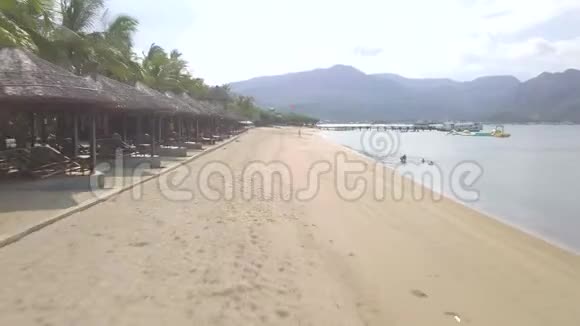 在热带岛屿和海岸的沙滩上飞行的无人机海边夏季游客休息和游泳视频的预览图